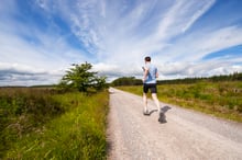Runner on a country road following an adaptive running plan