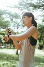 Runner checking her training data on her phone outdoors