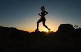 Runner silhouetted against a sunrise