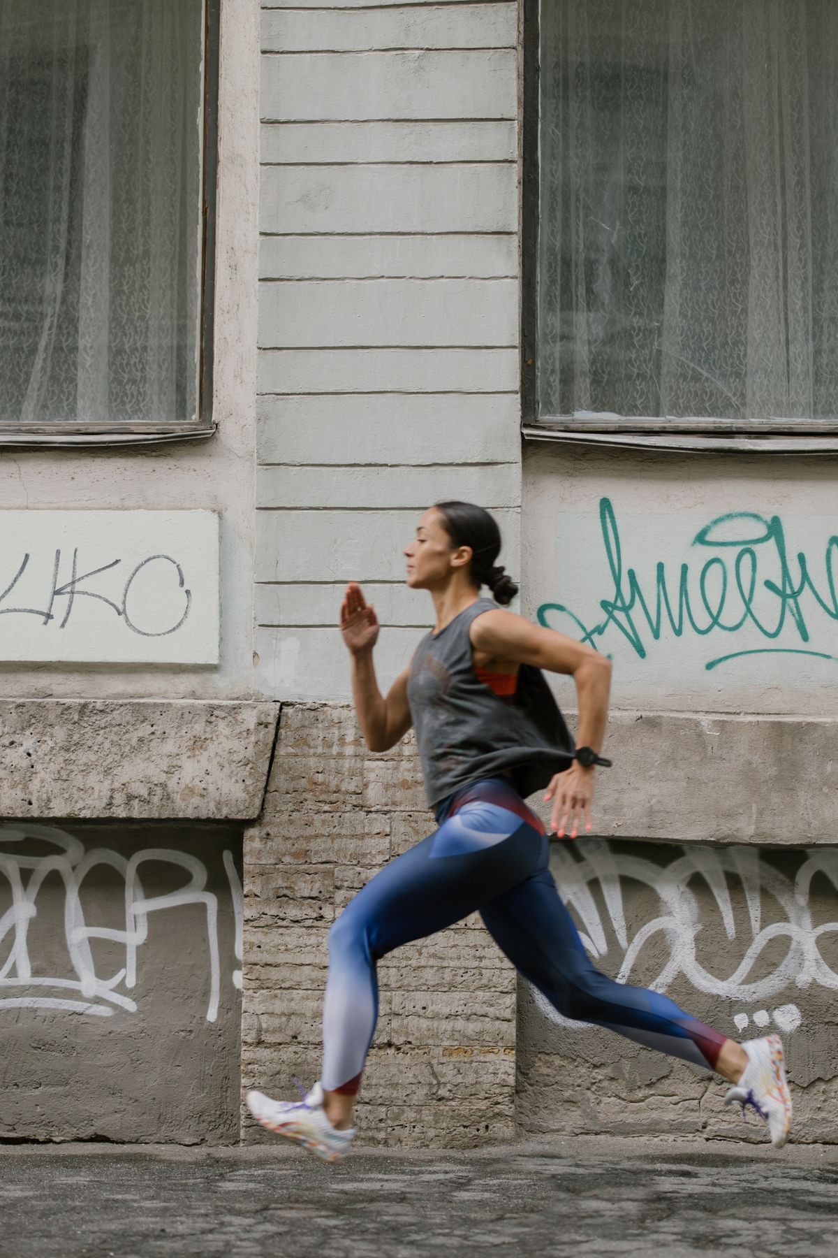 Female runner sprinting through city